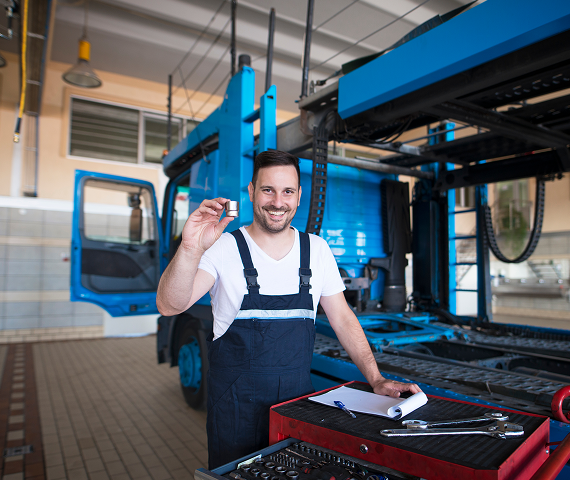 experienced-middle-aged-truck-mechanics-holding-parts-tools-repair-shop-by-truck